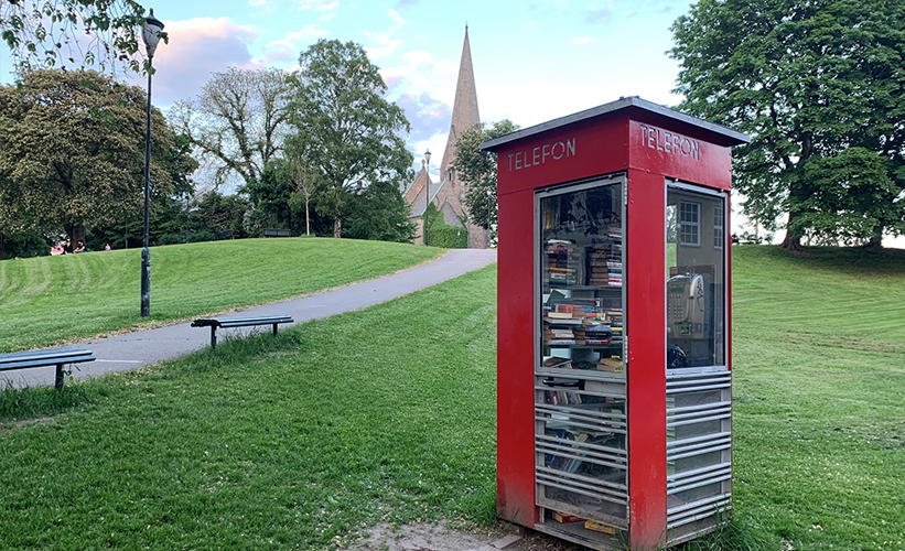 Red phone booth at a park in Oslo, Norway